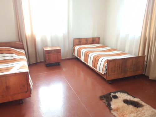a bedroom with two beds and a dog laying on the floor at Aisi in Stantsiya Sagaredzho