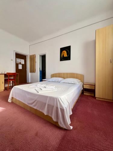 a bedroom with a large white bed in a room at Sinziana Eforie Sud in Eforie Sud