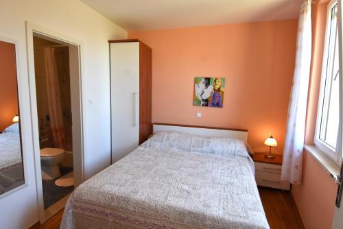 a small bedroom with a bed and a bathroom at Villa NADA 1 in Podgora