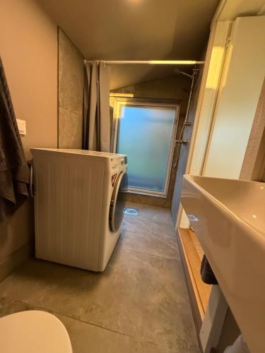 a small bathroom with a washer and dryer in it at Rävboet in Österbi