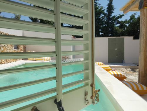 a room with a swimming pool through a sliding door at LE SORELLE Sea front -villa whit private pool in Scopello