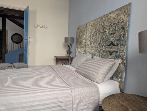 a bedroom with a white bed with a large headboard at The Artist's House in Céret