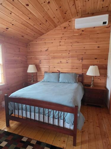 a bedroom with a bed in a log cabin at Rivers Edge Cabins - Tranquil Nook in Cushing