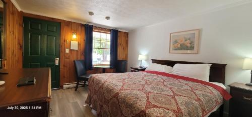 a bedroom with a bed and a green door at The Tallwood Motel in Wells