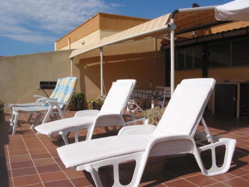 アルゲーロにあるAlghero, casa di Roberto IUN R7417の白い芝生の椅子が並ぶパティオ