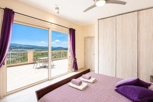 a bedroom with a bed and a large window at Villa Christel in Lachi