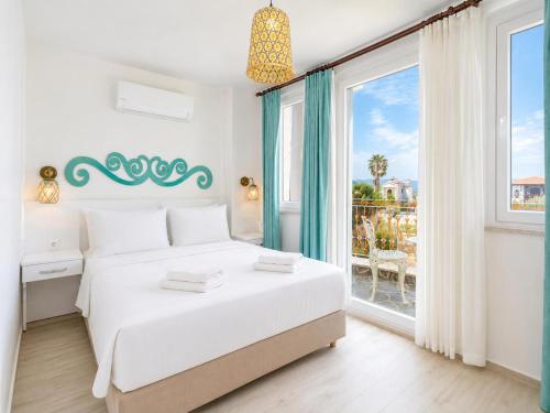 a white bedroom with a bed and a large window at Villa Portakal Blossom in Dalyan