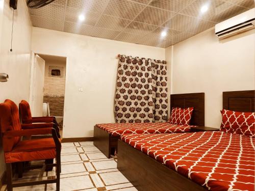 a bedroom with a bed and a chair at Lasani view Guest House in Lahore