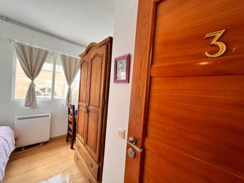 a bedroom with a wooden door and a bed at HOSTAL MATILDAs in Segovia