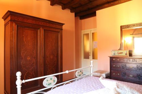 a bedroom with a bed and a dresser and a mirror at Guest House I Vicini di Cesare in Castelnuovo