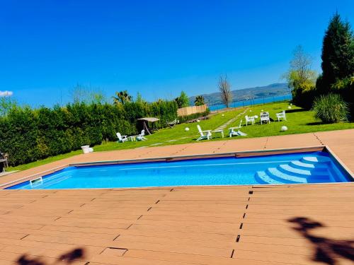 a large swimming pool with chairs and a grassy field at Göl Konuk Evi in Sakarya