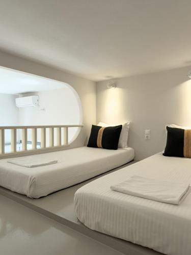 two beds sitting next to each other in a room at Villa Alisachni Andros in Agia Eleousa