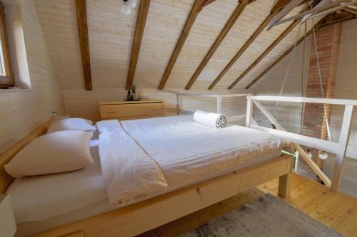 a bedroom with a bed in a wooden room at Golubek Holiday House in Banščica