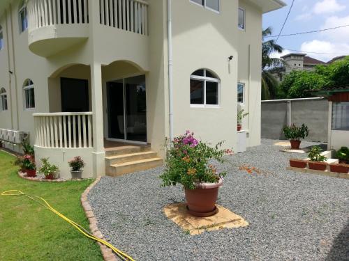 a house with a garden and a hose at Flower Garden Self-Catering Apartments in Beau Vallon