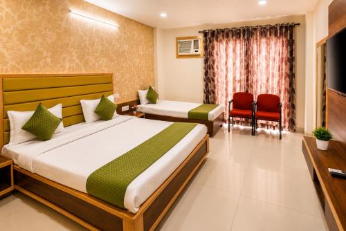 a hotel room with two beds and two chairs at Khatu Bagh Resort in Sīkar
