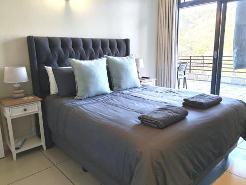a bedroom with a large bed with two towels on it at Stay at the Herold 605 in Herolds Bay