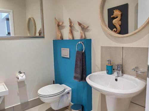 a bathroom with a toilet and a sink and a mirror at Stay at the Herold 605 in Herolds Bay