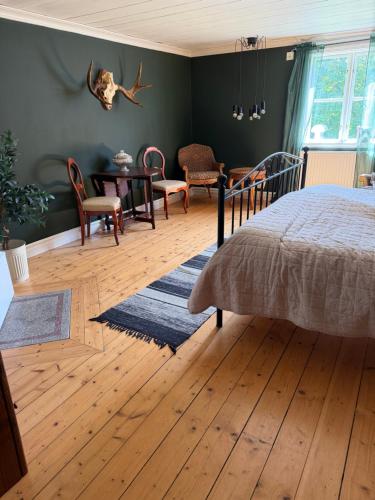 a bedroom with a bed and a table and chairs at Flishult gård in Vetlanda