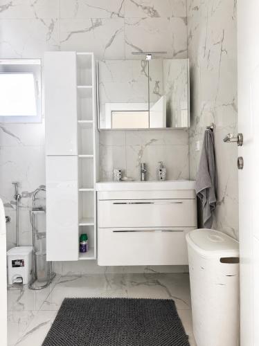 a white bathroom with a sink and a mirror at La Hacienda Percobic-Serenity & private pool in Bar