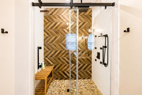 a shower in a bathroom with a wooden wall at Pool House Near NYC FIFA Stay for Groups in Roselle