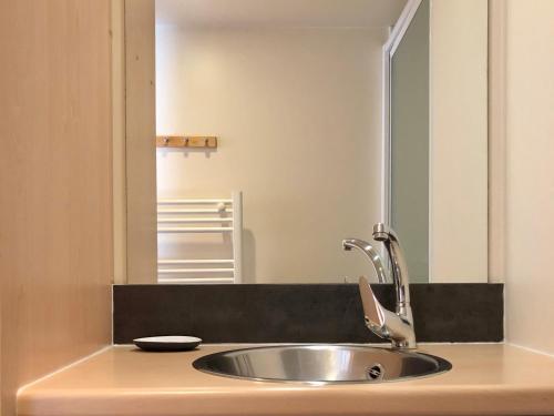 a bathroom with a sink and a mirror at Camping Pré-Fixe in Cassagnabère-Tournas