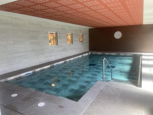 a large swimming pool with a tile floor at DOMITYS - Villa Molinis in Moulins