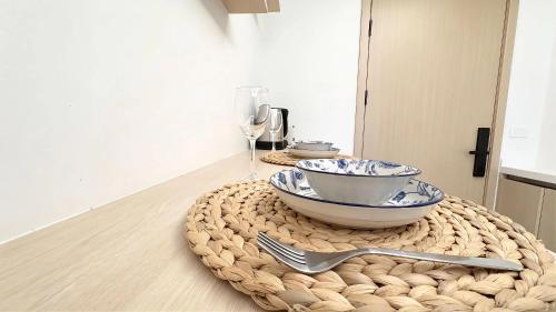 a table with a bowl and a fork on a wicker table at Peaceful Fantasia Condo Kamala in Surin Beach