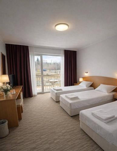 a hotel room with two beds and a window at Hotel Jasmine in Byala