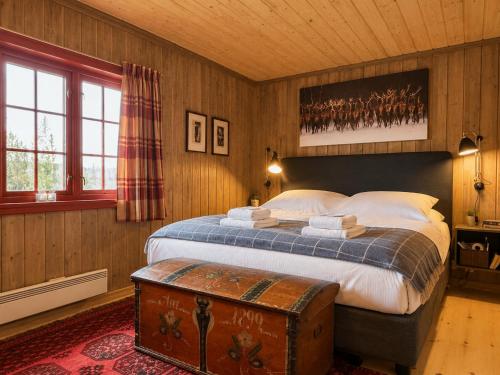 a bedroom with a large bed with a trunk in it at Spacious cabin with beautiful Geilo views in Geilo