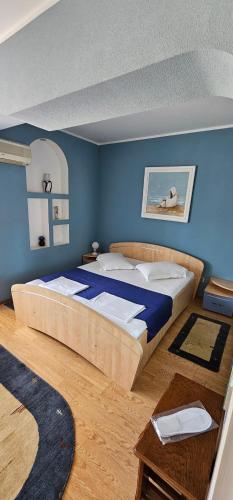 a bedroom with a large bed with blue walls at Casa Belu in Eforie Nord