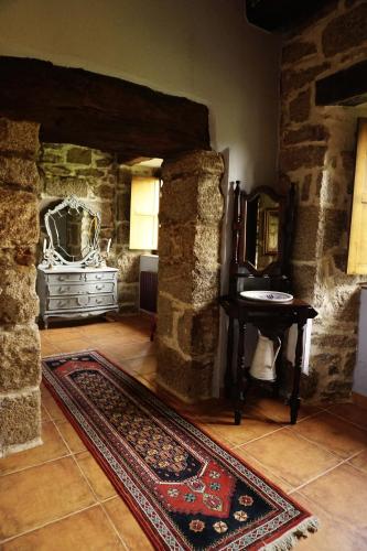 a room with a rug and a table and a mirror at Casa de San Pedro de Cerceda in Villasante