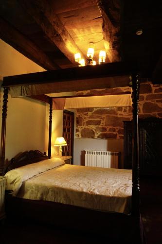 a bedroom with a canopy bed in a room at Casa de San Pedro de Cerceda in Villasante