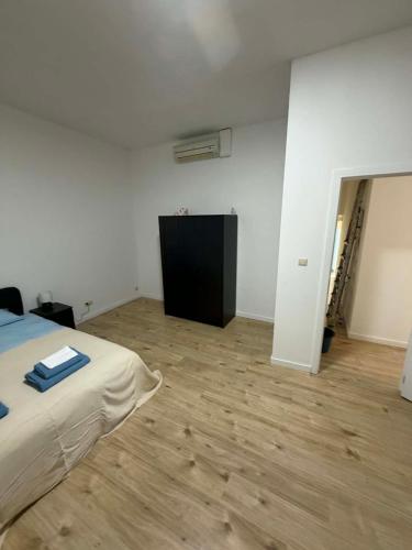 a bedroom with a bed and a wooden floor at 1 Grande Chambre Frigo privé in Charleroi