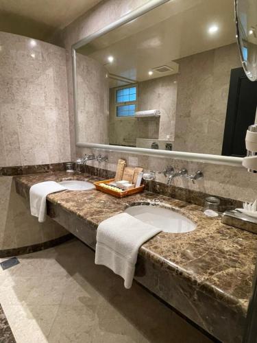 a bathroom with two sinks and a large mirror at منتجع موفون بيتش in Al Khobar
