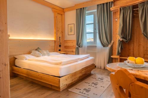 ein Schlafzimmer mit einem Bett und einem Tisch mit einer Obstschale in der Unterkunft Agritur Golden Pause in Ton