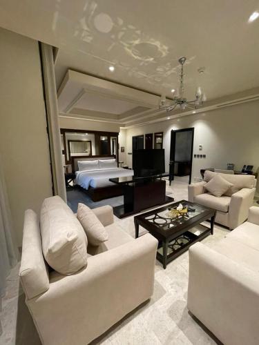 a large living room with white furniture and a bed at منتجع موفون بيتش in Al Khobar