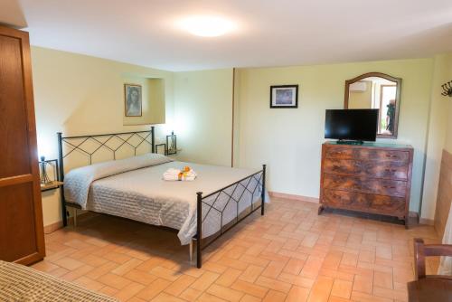 a bedroom with a bed and a dresser with a television at Il Nido del Falco in Montefalco