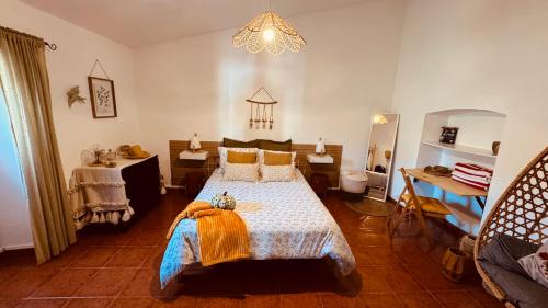 a bedroom with a large bed and a chandelier at Monte do Pópulo in Estremoz