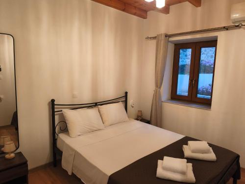 a bedroom with a bed with two towels on it at Tsitsinos Village Cottage in Zekros
