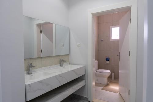 a white bathroom with a sink and a toilet at The view apartment 2 in Al Baha