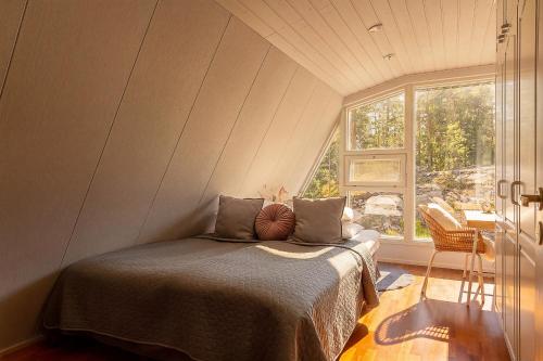 a bedroom with a bed in a room with a window at Stay North - Merimaa in Tallbacka