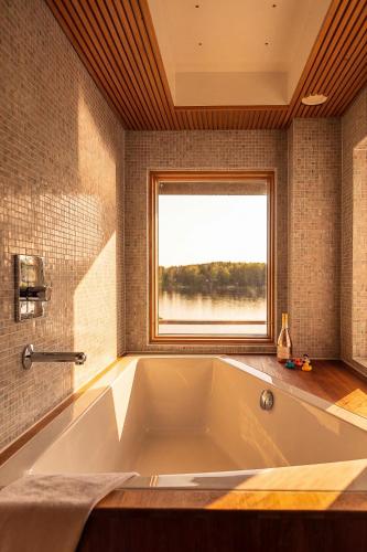 a large bath tub in a bathroom with a window at Stay North - Merimaa in Tallbacka