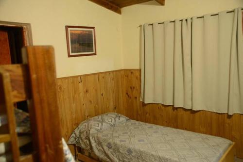a small bedroom with a bed and a window at Las Grutas Centro alojamiento in Las Grutas