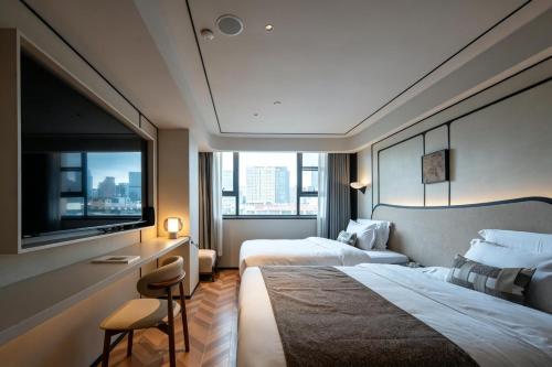 a hotel room with two beds and a large window at Neyar Luxury and Tranquil Aesthetics Hotel-Prime Location,8-min Walk to Chunxi Road & Sino-Ocean Taikoo Li in Chengdu