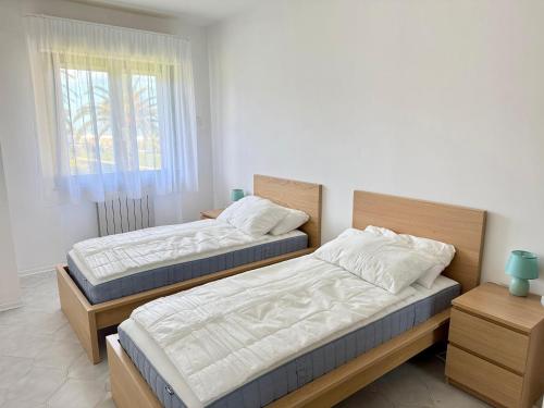 two twin beds in a room with a window at Residence Leonardo sul mare in Silvi Marina
