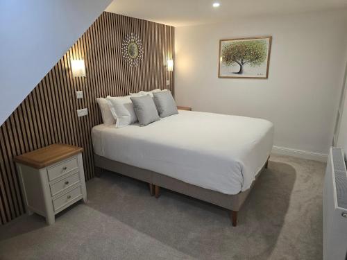 a bedroom with a large bed with a wooden headboard at Dunderry Lodge Luxury Suites in Navan