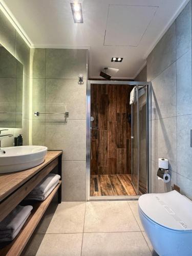 ein Badezimmer mit Dusche, Toilette und Waschbecken in der Unterkunft Axis Hotel in Cimenli