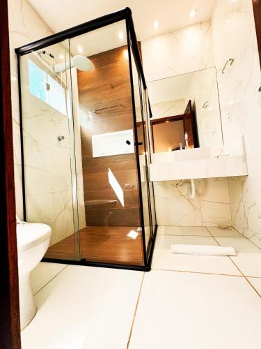 a bathroom with a shower and a toilet at Casa Quebec - Apartamentos in São Miguel do Gostoso