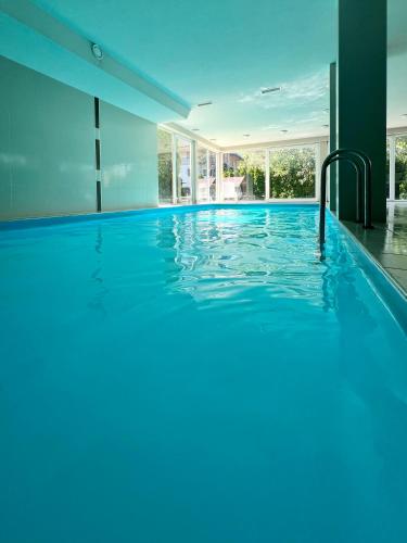 a swimming pool with blue water in a house at Wellness Dorina in Siófok