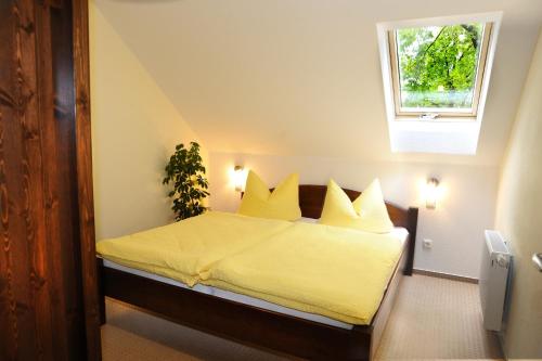 a bedroom with a bed with yellow sheets and a window at KASTANIENHOF I in Burg